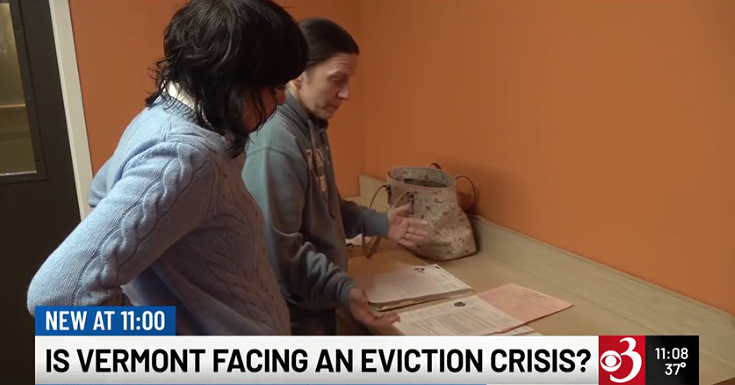 Still image from news story where two women look at paperwork