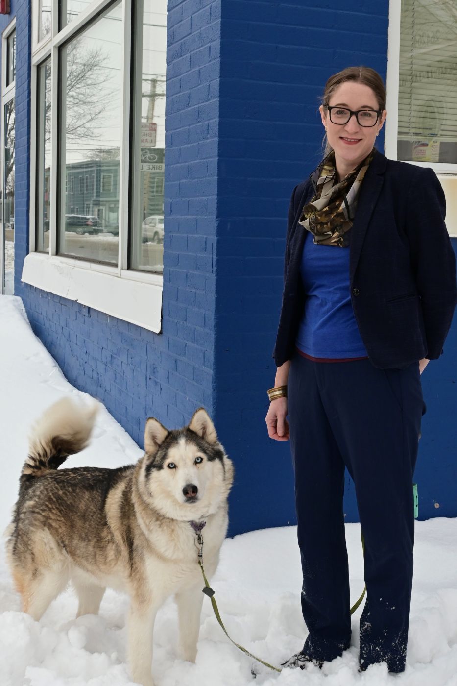 Maggie and her dog standing outside the office